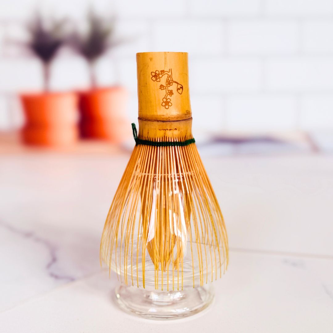 Bamboo whisk with glass base on a blurred background