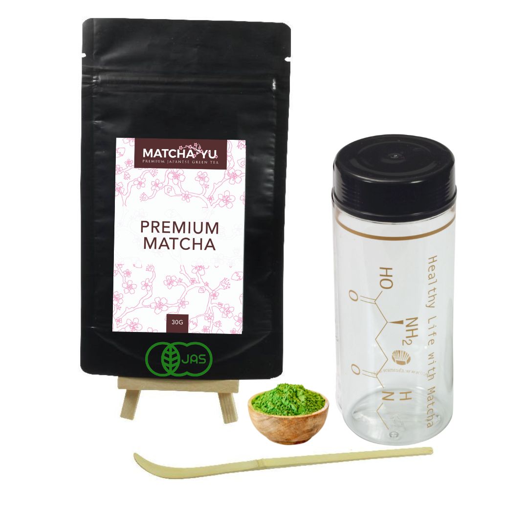 Matcha Yu premium matcha packaging with a plastic container, wooden bowl, and bamboo whisk on a white background.