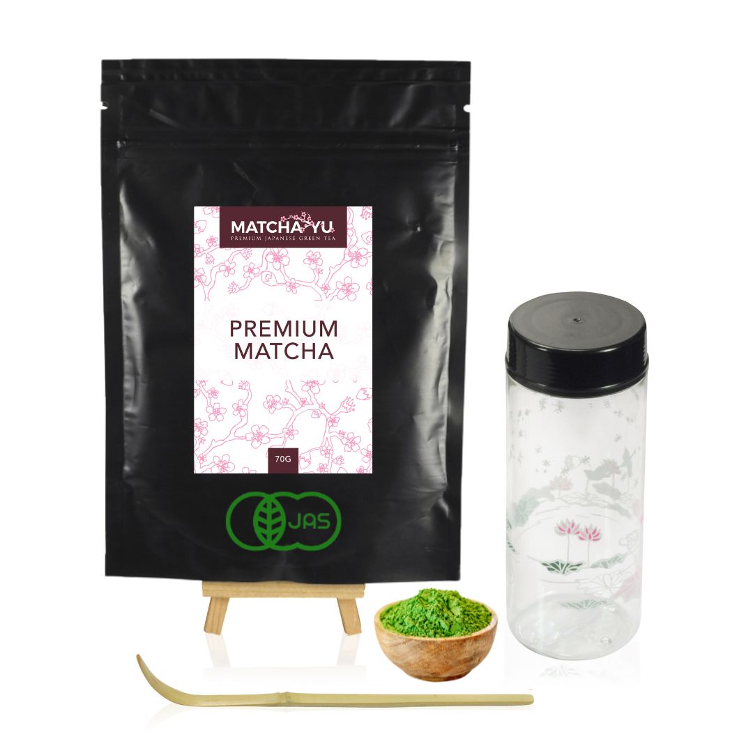 Matcha packaging with a bowl of matcha powder, whisk, and container on a white background