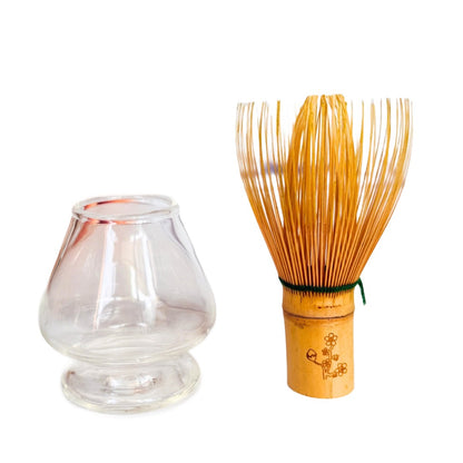 Clear glass container and wooden whisk on a white background