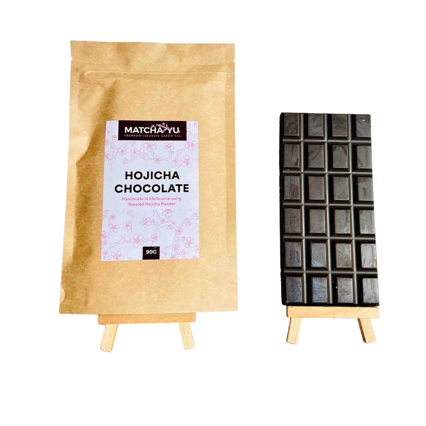 Hojicha chocolate packaging with a bar on wooden stands against a white background