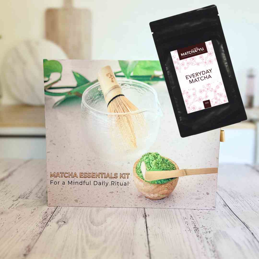Matcha essentials kit with packaging and matcha powder package on a wooden surface.