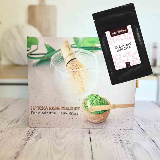 Matcha essentials kit with packaging and matcha powder package on a wooden surface.