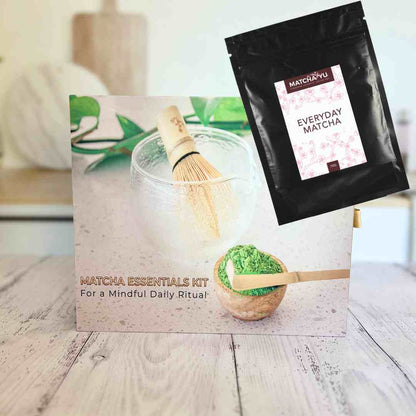 Matcha essentials kit with packaging and matcha powder on a wooden surface