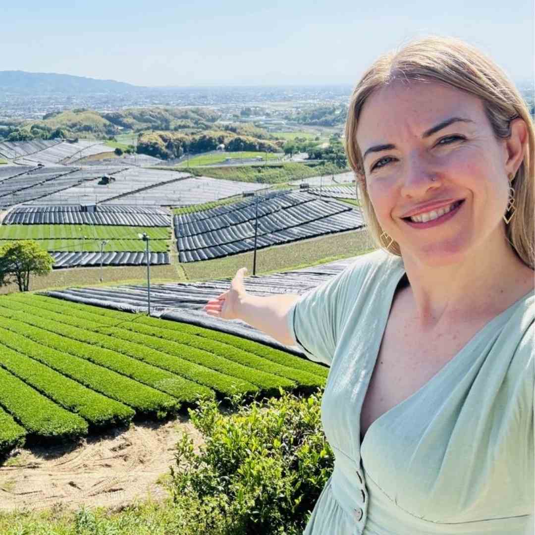 Woman standing in front of vast tea plantation