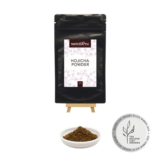 Matcha Yu Hojicha Powder packaging with a small bowl of powder and a Golden Leaf Award badge on a white background