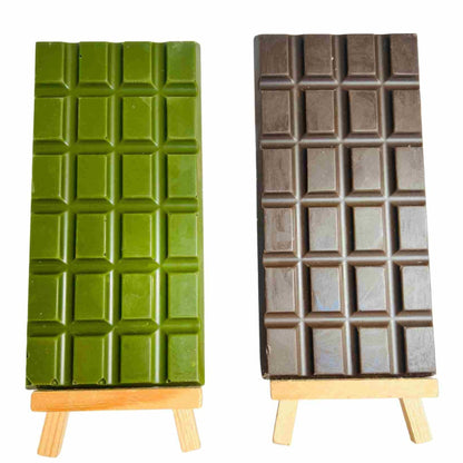 Two chocolate bars on stands, one green and one brown, against a white background