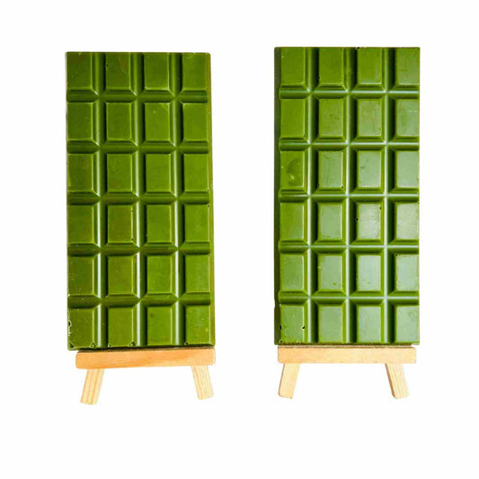 Two green chocolate bars on wooden stands against a white background