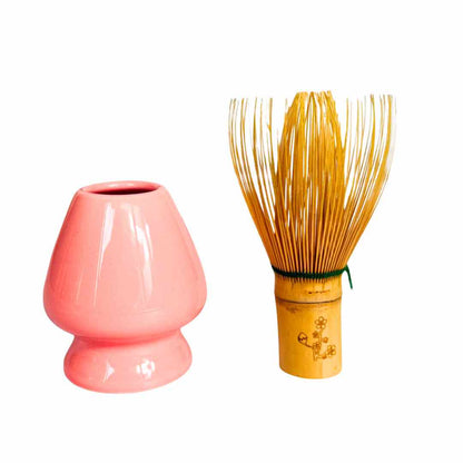Pink ceramic whisk and wooden whisk on a white background