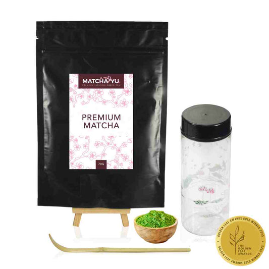 Matcha-yu premium matcha packaging with a bowl of matcha powder, whisk, and container on a white background.