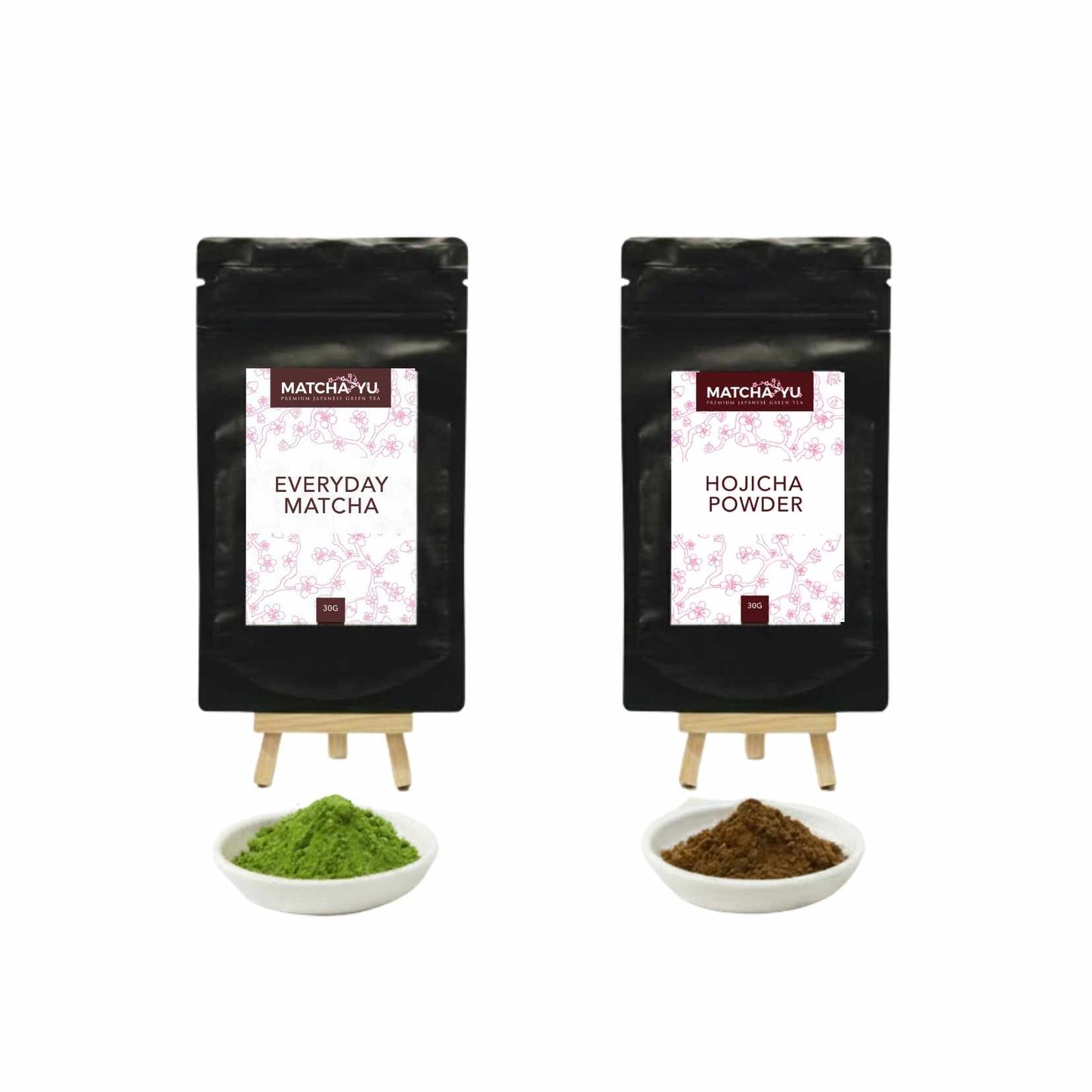 Two black packages of Matcha Yu with matcha powder and green tea leaves on white background