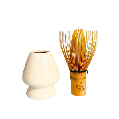 White ceramic whisk holder and wooden whisk on a white background